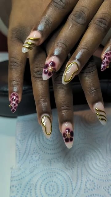 Almond nails with gold chrome swirls and floral art by Rue Nails